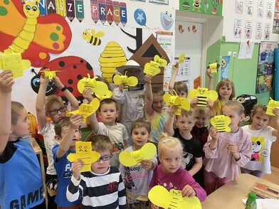 Dzieci trzymające ozdoby w kształcie pszczół